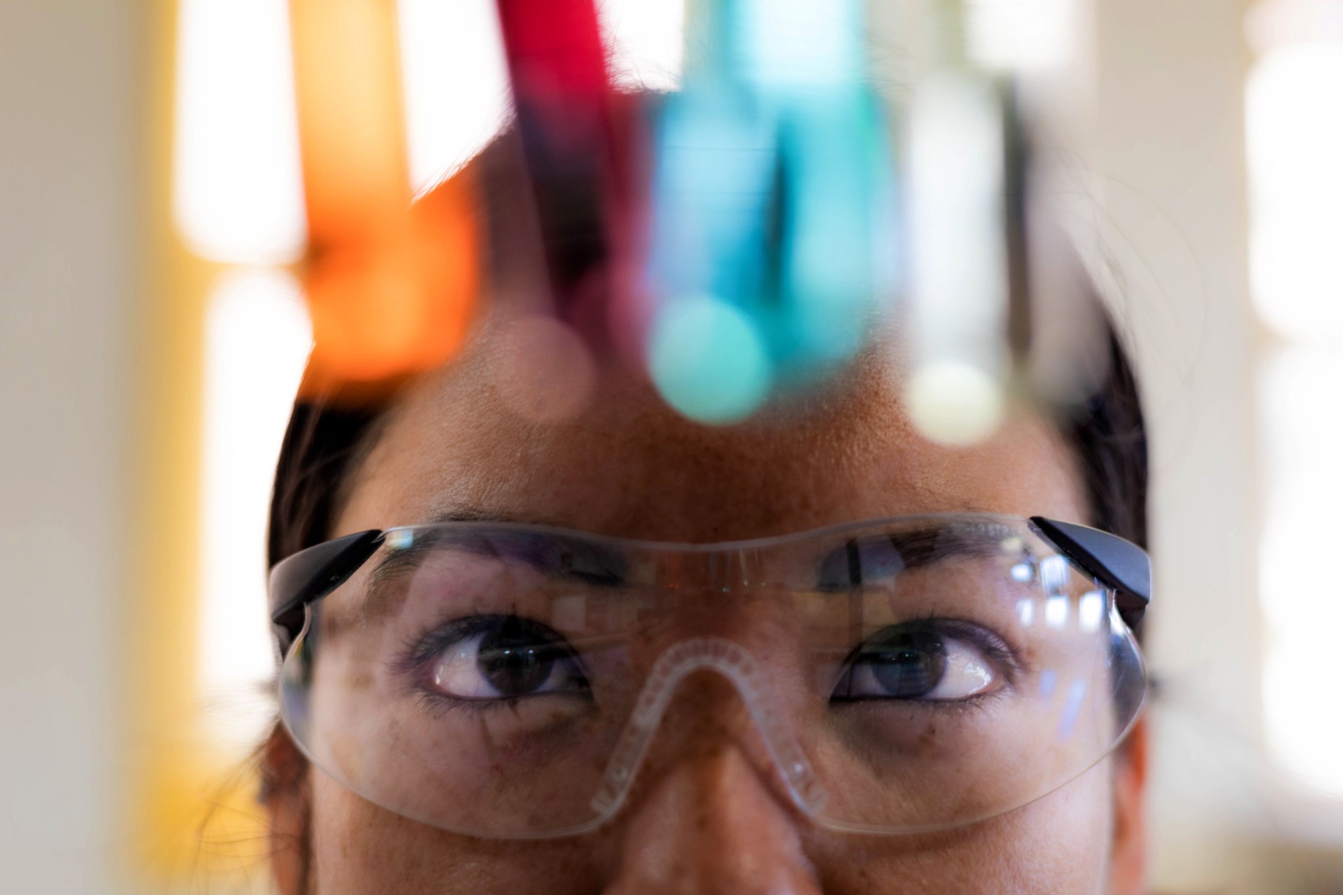 a scientist observing colorful liquid in test tubes